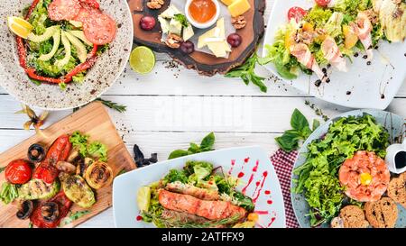 Ein Set Lebensmittel. Tatar, Käse, Salat und Gemüse. Auf Holzgrund. Draufsicht. Kopierbereich. Stockfoto