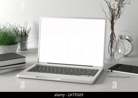 Arbeitsbereich mit leerem Laptop-Monitor mit weißem Bildschirm auf dem weißen Schreibtisch in der Nähe der weißen Wand Stockfoto