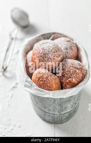 Köstliche Donuts Kugeln mit Puderzuckerpulver im kleinen Eimer Stockfoto