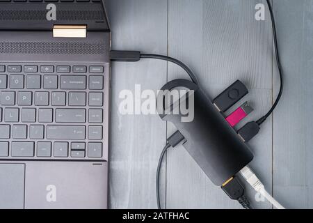 USB-Adapter Typ C oder Hub, der mit verschiedenen Zubehörteilen an den Laptop angeschlossen ist - Pendreifen, hdmi, ethernet, Kabel. Flacher Lay Draufsicht. Stockfoto