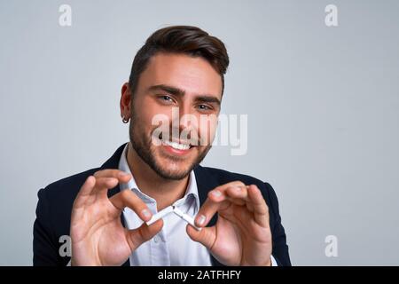 Nahaufnahme Portrait junger Mann Geschäftsmann kaukasischer Kerl Business Anzug Studio grauer Hintergrund. Moderne Geschäftsleute brechen eine Zigarette und hörten auf zu rauchen Stockfoto