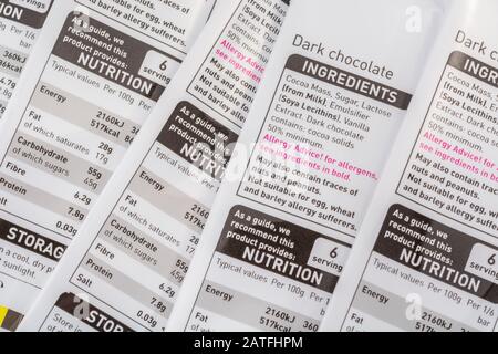 Asda dunkle Schokoladenverpackungen mit Lebensmittel-Infobox, Warnung vor Allergen von roten Lebensmitteln, Inhaltsstoffgehalt, Lebensmittel-Label-Nahaufnahme. Stockfoto