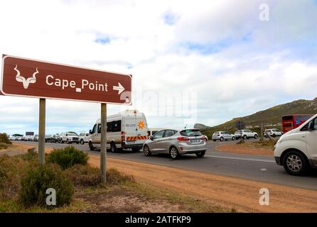 Wegweiser zum Cape Point mit einer Warteschlange von Autos, die auf den Eintritt in den Table Mountain National Park und das Kap der Guten Hoffnung in Südafrika warten Stockfoto