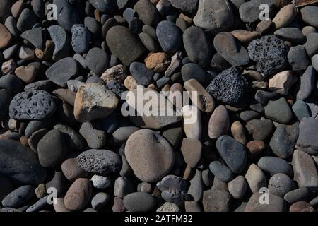 Meeressteine Hintergrund. Graue, weiße Steine am Strand Stockfoto