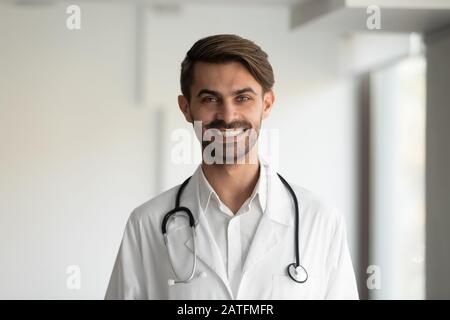 Kopfschuss Porträt lächelnder Arzt mit Uniform mit Stethoskop am Hals Stockfoto