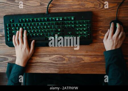 Computersatz. Gaming-Tastatur mit rgb-Beleuchtung, die Hand in Spielposition hat. Stockfoto
