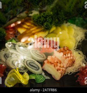 Farbenfrohes, köstliches Set aus japanischem, farbenfrohem Sashimi aus Tintenfisch, Tintenfisch, heller Zitrone und Gurke, Schaufenster mit Meeresfrüchten Stockfoto