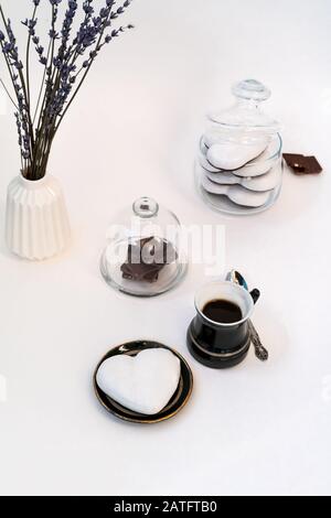 Valentinstag Stillleben mit Tasse Kaffee, Chokolate und Teller mit herzförmigem Ingwerkeks auf weißem Hintergrund. Valentines Tag Celebration Konzept Stockfoto