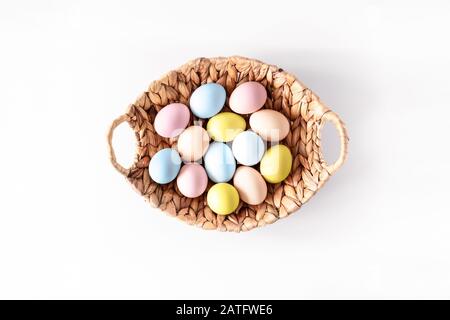 Bunte Eier in einem Korb auf weißem Hintergrund. Natürliche gesunde Lebensmittel und ökologischer Landbau, easter- und Frühlings-Konzept. Stockfoto