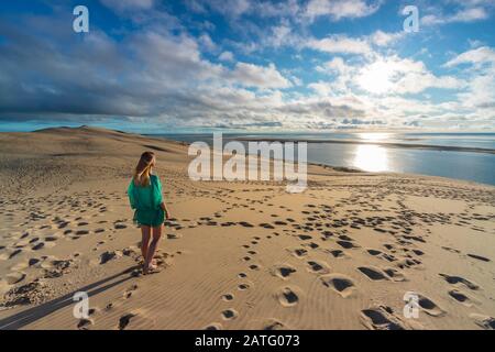 Eine Frau über Dune Du Pilat bei Sonnenuntergang, Pyla sur Mer, Teste de Buch, Gironda, Frankreich, Westeuropa Stockfoto