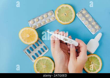 Medikamente, Pillen, Thermometer, traditionelle Medizin für die Behandlung von Erkältungen, Grippe, Wärme auf einem blauen Hintergrund. Aufrechterhaltung der Immunität. Saisonale Krankheiten Stockfoto