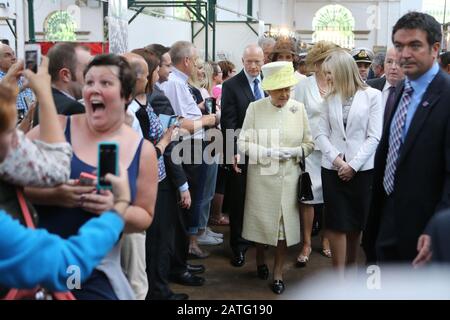 Eine Frau versucht einen selfie zu tun, während die britische Königin Elizabeth II. Tours St. Georges Markt in Belfast, Dienstag, Juni 24th, 2014. Die Königin ist auf einer 3-tägigen Tour von Nordirland. POOL Foto/Paul McErlane Stockfoto