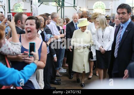 Eine Frau versucht einen selfie zu tun, während die britische Königin Elizabeth II. Tours St. Georges Markt in Belfast, Dienstag, Juni 24th, 2014. Die Königin ist auf einer 3-tägigen Tour von Nordirland. Foto/Paul McErlane Stockfoto