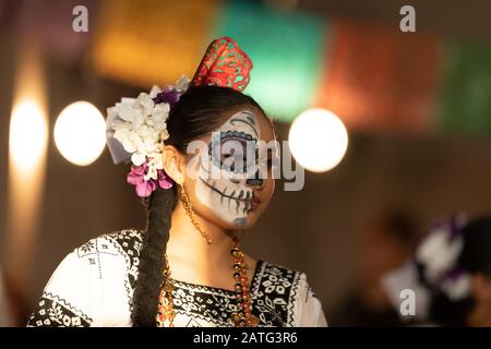 Indianapolis, Indiana, USA - 2. November 2019: Day of the Dead, junge mexikanische Frau mit traditioneller Kleidung und mit Schädelgesicht, Performin Stockfoto