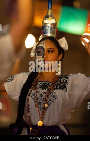 Indianapolis, Indiana, USA - 2. November 2019: Day of the Dead, Junge mexikanische Frau mit traditioneller Kleidung und Gesichtsfarbe, die die Abfüllung durchführt Stockfoto