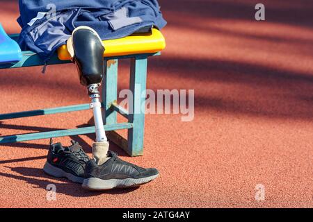 Turnschuhe und abgenommene prothetische Beine in der Nähe des Sitzes Stockfoto