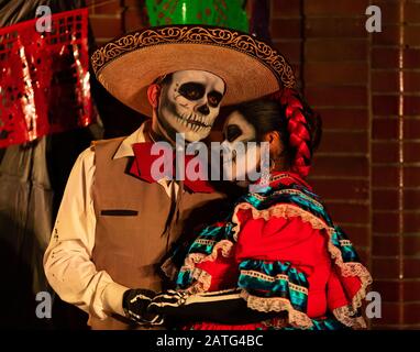Indianapolis, Indiana, USA - 2. November 2019: Day of the Dead, mexikanisches Paar verkleiden sich in traditioneller Kleidung und halten Hände Stockfoto