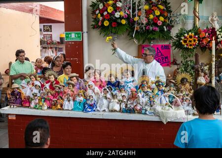 Oaxaca de Juarez, Mexiko. Februar 2020. Fr. Hector Zavala Balboa segnet Jesusbabypuppen, während er auf dem Sanchez Pascuas Nachbarschaftsmarkt auf der Dia de la Candelaria die Messe feiert. Das Ereignis feiert 40 Tage nach der Geburt Jesu. Familien verkleiden Puppen des Baby-Jesus und bringen sie zur Masse, um gesegnet zu werden. Kredit: Jim West/Alamy Live News Stockfoto