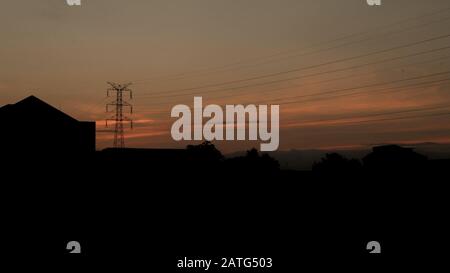 Baustelle und Elektropol mit Sonnenaufgang, Silhouette der Hochspannungs-Elektropole bei Sonnenaufgang oder Sonnenuntergang Stockfoto