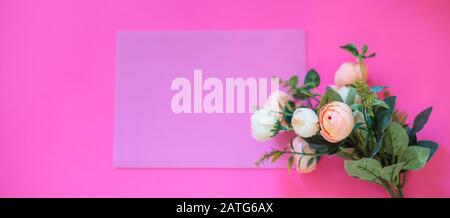 Rahmen aus Rosen auf pinkfarbenem Hintergrund. Flaches Lay. Draufsicht Stockfoto
