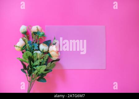 Rahmen aus Rosen auf pinkfarbenem Hintergrund. Flaches Lay. Draufsicht Stockfoto