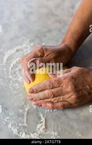 Italienische Frau knetet hausgemachten Nudelteig Stockfoto