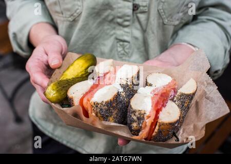 Frau, die Mohn mit Brote und Frischkäse hält Stockfoto