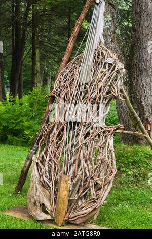 Doppel-Bass-Musikinstrumentenskulptur aus Cedrus - Zedernbaumzweige von Quebecois Kunsthandwerker Michel Giroux, Le Jardin de Francois Garden, Quebec Stockfoto