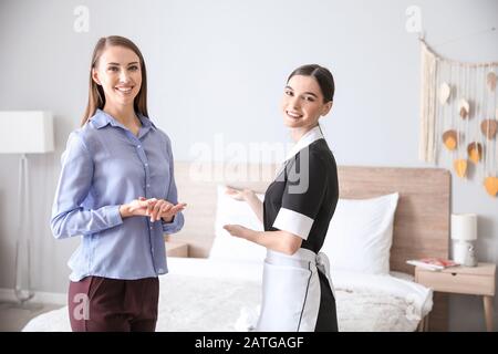 Manager und Zimmermädchen im Hotelzimmer Stockfoto