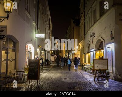 Prag, TSCHECHIEN - 31. OKTOBER 2019: Zelezna Straße bei Nacht mit Touristen vorbei. Die mit Kopfsteinpflaster gepflasterte Straße ist ein Wahrzeichen des Stockfoto