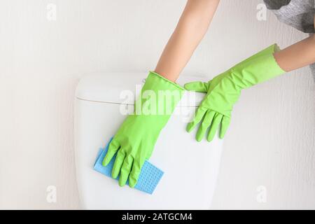 Junge Frau putzte toilette im Bad Stockfoto