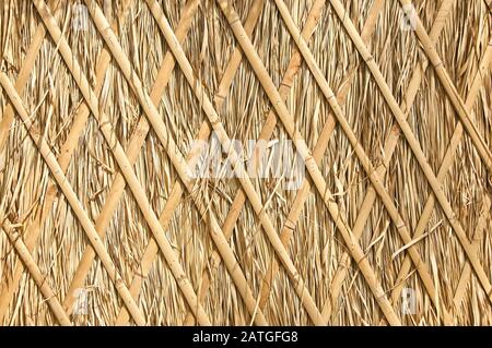 Nahaufnahme von Strohdach, Hay- oder Trockenrasenhintergrund, Strohdach, Grasheu, trockenem Strohhalm, Dachhintergrundstruktur. Stockfoto