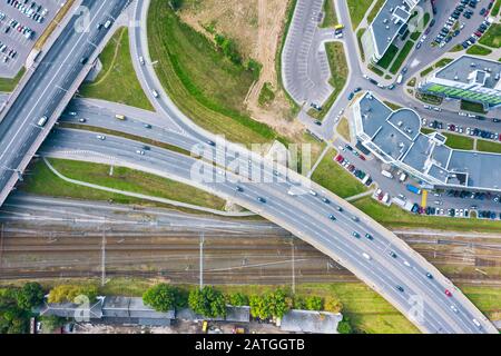 Mehrstufige Kreuzung von Straßen- und Bahngleisen in der Stadt. Luftbild des Stadtverkehrs Stockfoto