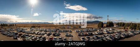 Bariloche, ARGENTINIEN, 22. JUNI 2019: Panoramaaussicht auf überfüllte Flughafen-Parkplätze mit vielen Fahrzeugen an einem sonnigen Tag mit Bergen über dem Stockfoto