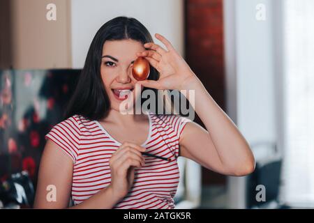 Ostern, Feiertage, Frau färbt ostereier mit Pinsel Stockfoto