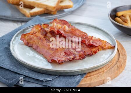 Knuspriger gebratener Speck auf einem Teller. Stockfoto