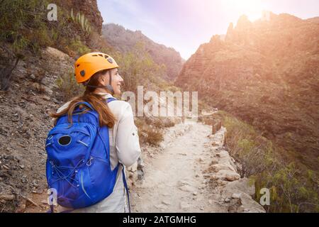 Touristenmädchen mit Helm auf dem Trekkkingpfad in der Schlucht von Tenera, Spanien Stockfoto