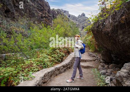 Junge Wanderfrau in üppig grünem Canyon auf Teneras, Spanien Stockfoto