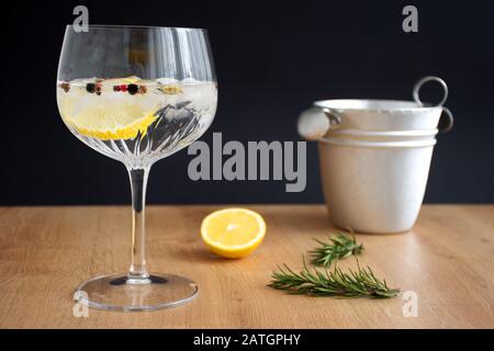 Gin und Tonika mit Zitrone und Rosmarin aus Kristallglas auf dem Holztisch Stockfoto