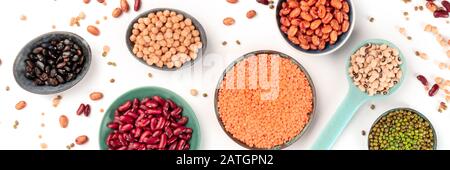 Pulses panoramic Banner, ein Overhead-Shot auf weißem Hintergrund. Schwarze und rote Nierenbohnen, Linsen, Sojabohnen, Kichererbsen, ein flacher Lay Stockfoto