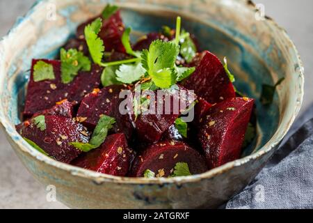 Gebackener Rote-Bete-Salat mit Cilantro in einer Schüssel. Gesundes veganes Lebensmittelkonzept. Stockfoto
