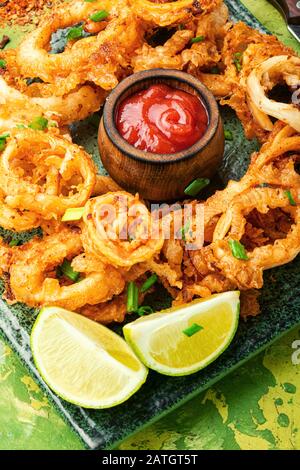 Knackige, frittierte Tintenringe im Teig. Gebratene Tintenringe mit Kalk gegrillt Stockfoto