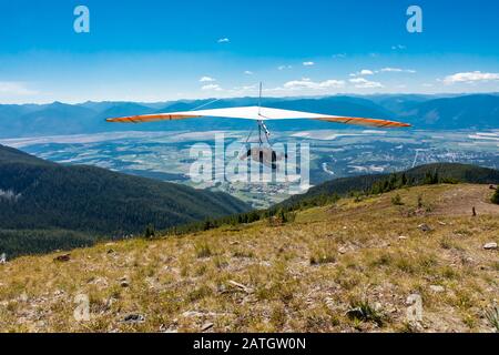 Drachenflieger starten auf der Bergkuppe. Gleitschirmflieger, der über Kootenay Valley Mountains, Creston, British Columbia, Kanada fliegt Stockfoto