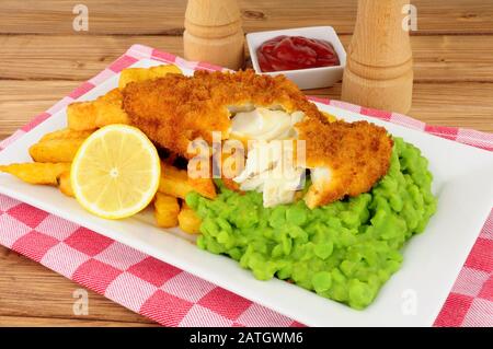 Fisch und Pommes mit matschigen Erbsen Stockfoto