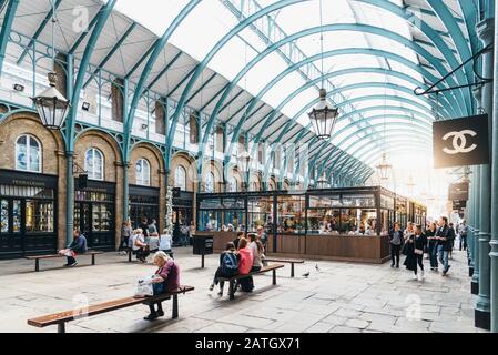 London, Großbritannien - 15. Mai 2019: Menschen, die auf dem Covent Garden Market genießen, mit Blick auf die Sonne. Covent Garden liegt im Londoner West End und ist bekannt für seine Lage Stockfoto