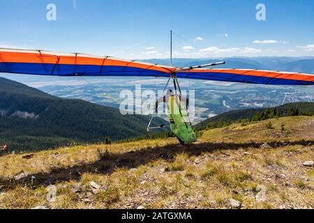 Drachenflieger fahren und starten. Malerische Aussicht auf die Kootenay-Talberge. Blick von hinten auf fliegende Hängegleiter Stockfoto