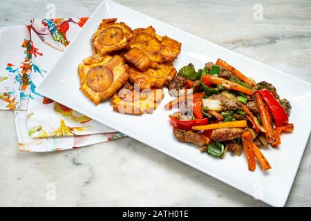 Gehackte Steak- oder Bistec Picao- und Patacone- oder Tostones sind gebratene grüne Plantaschscheiben, die aus grünen Kochbananen, Tipischen Panamá-Lebensmitteln, Panamá, Centr. Hergestellt werden Stockfoto