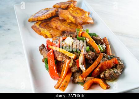 Gehackte Steak- oder Bistec Picao- und Patacone- oder Tostones sind gebratene grüne Plantaschscheiben, die aus grünen Kochbananen, Tipischen Panamá-Lebensmitteln, Panamá, Centr. Hergestellt werden Stockfoto