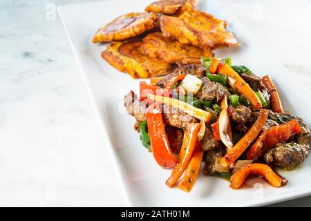 Gehackte Steak- oder Bistec Picao- und Patacone- oder Tostones sind gebratene grüne Plantaschscheiben, die aus grünen Kochbananen, Tipischen Panamá-Lebensmitteln, Panamá, Centr. Hergestellt werden Stockfoto