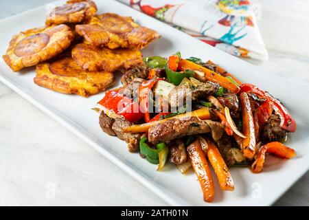 Gehackte Steak- oder Bistec Picao- und Patacone- oder Tostones sind gebratene grüne Plantaschscheiben, die aus grünen Kochbananen, Tipischen Panamá-Lebensmitteln, Panamá, Centr. Hergestellt werden Stockfoto